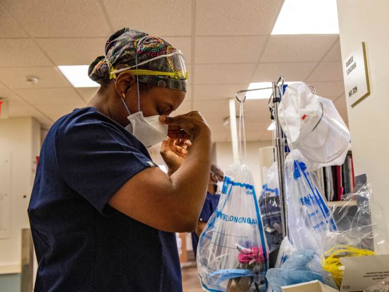 A medical worker puts on a mask before entering a negative pressure room with a Covid-19 patient in the ICU ward at UMass Memorial Medical Center in Worcester, Mass. on January 4, 2022. (Joseph Prezioso/AFP via Getty Images)