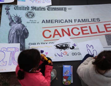 Children draw on top of a canceled check prop