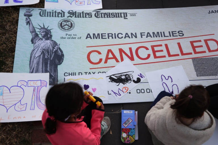 Children draw on top of a canceled check prop