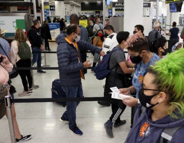 MIAMI, FLORIDA - DECEMBER 28:  Travelers make their way through Miami International Airport on December 28, 2021 in Miami, Florida. Over the holiday weekend, COVID-19 cases in the U.S. reached their highest level in nearly a year. More than 2,000 flights were canceled over the weekend as airlines dealt with a surge in COVID-19 cases due to the Omicron variant. (Photo by Joe Raedle/Getty Images)