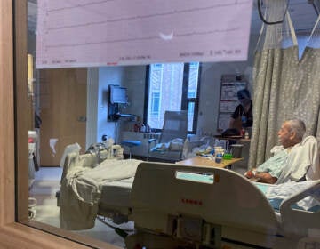 A patient sits in bed on the COVID-19 ward at Harborview Medical Center in Seattle on January 14, 2022. COVID patients are filling up acute-care units here and at hospitals around the country, even though omicron tends to cause milder cases. (Will Stone/NPR)