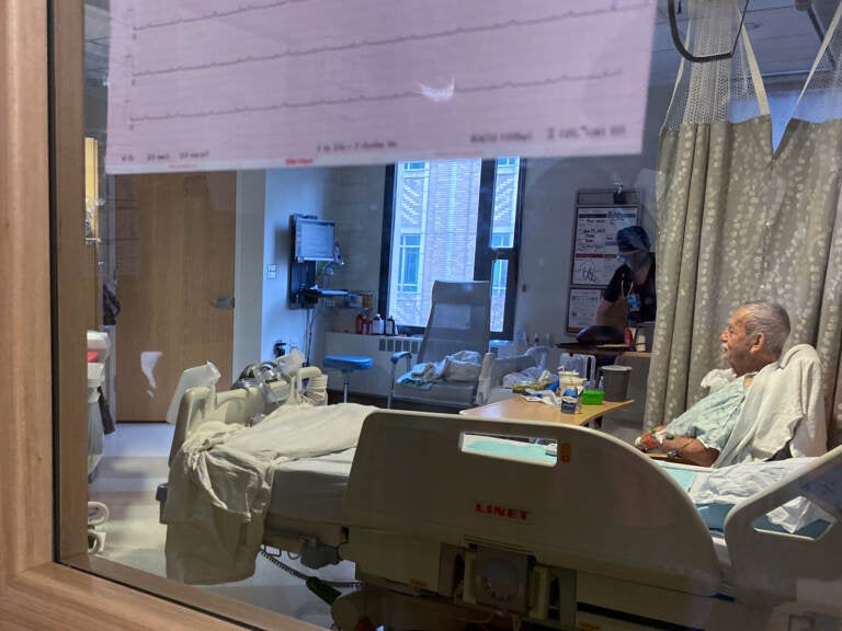 A patient sits in bed on the COVID-19 ward at Harborview Medical Center in Seattle on January 14, 2022. COVID patients are filling up acute-care units here and at hospitals around the country, even though omicron tends to cause milder cases. (Will Stone/NPR)