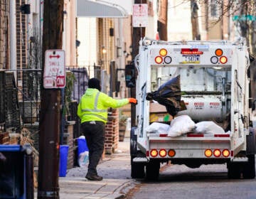 A municipal sanitation worker collects trash in Philadelphia