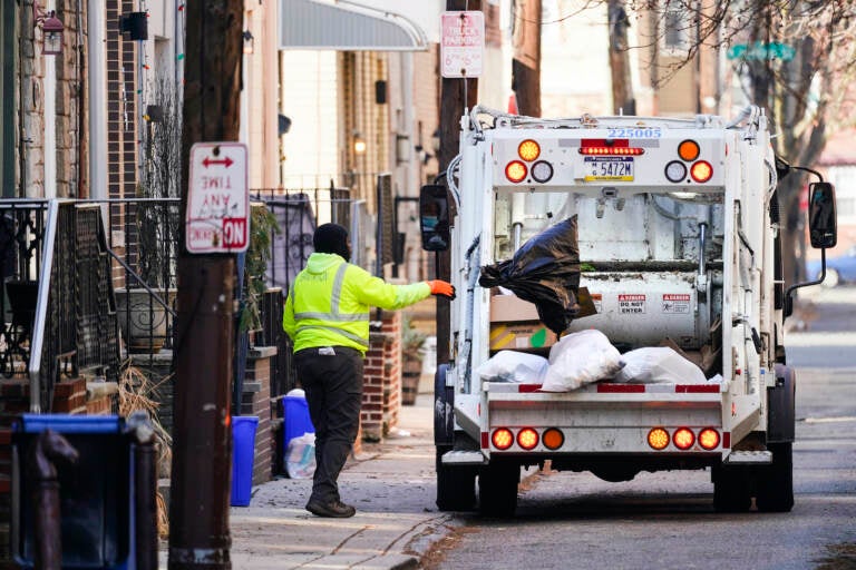 A municipal sanitation worker collects trash in Philadelphia