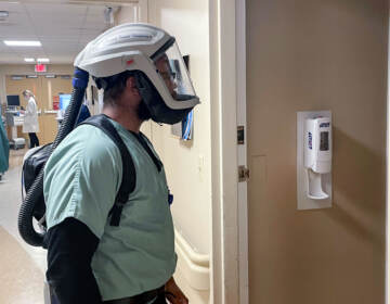 Raynell Peacock prepares to enter a patient's room while wearing a breathing apparatus