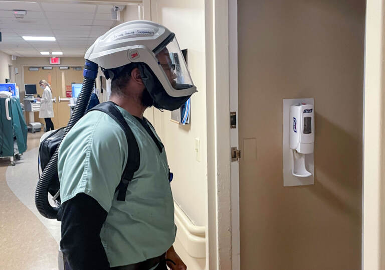 Raynell Peacock prepares to enter a patient's room while wearing a breathing apparatus