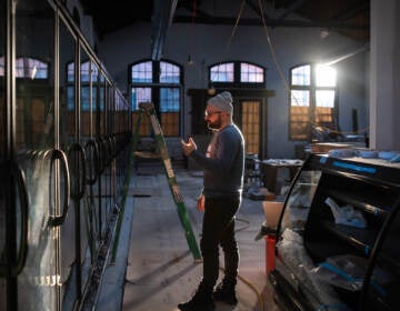 Vincent Finazzo gestures while standing inside a warehouse under construction