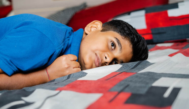 A child crying and anxious lying down on a blanket