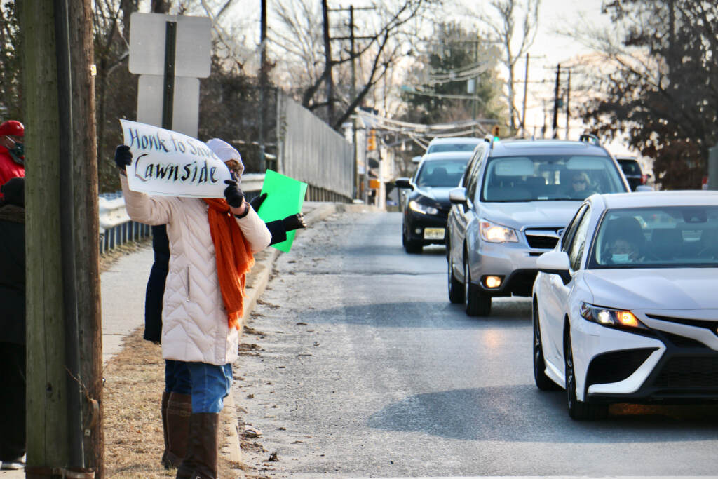 Lawnside resident Linda Shockley enlists the support of passing drivers on Warwick Road during a protest