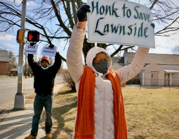 Linda Shockley (right) and Stanley Conaway Jr. protest outside. Linda holds a sign that says, 
