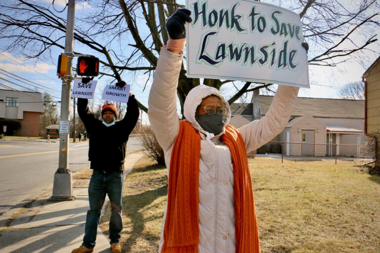 Linda Shockley (right) and Stanley Conaway Jr. protest outside. Linda holds a sign that says, 