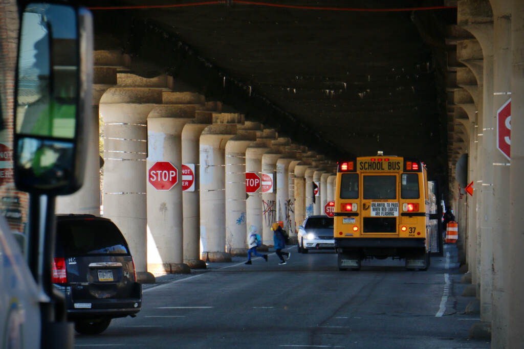 Children get off their school bus below the 25th Street Viaduct
