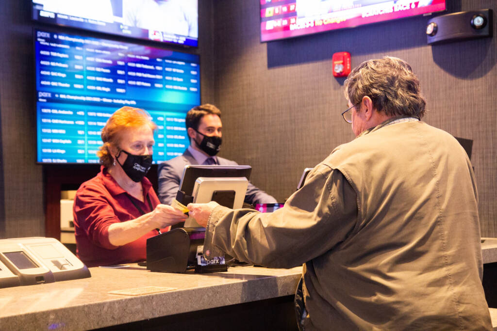 A worker speaks with a customer at Parx Casino