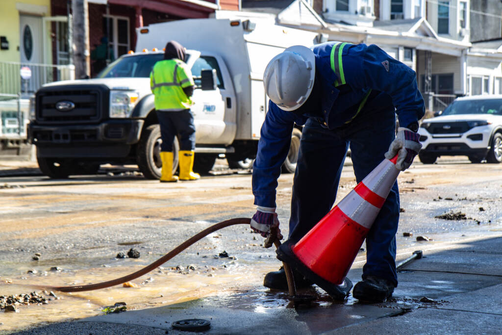 Workers with the Philadelphia Water Department and Philadelphia Gas Works evaluate damage and cap utility lines