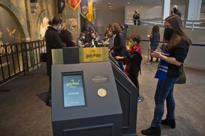 Guests of ''Harry Potter™: The Exhibition'' receive a wrist band and register as they enter the exhibit, allowing them to interact with the Wizarding World. (Kimberly Paynter/WHYY)