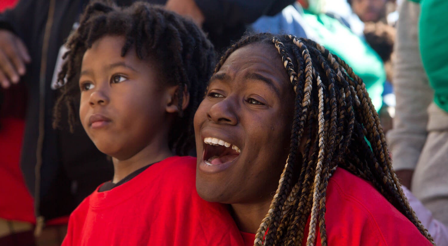 Yaszmin Belton, a music teacher at Gratz high school and a volunteer with Frontline Dads, with her son, Elo, 3, at the opening of The Teen Safe Space on North Broad Street in Philadelphia, on February 21, 2022. Belton was ecstatic that she could tell students who ask her where to go after school to come to the space. (Kimberly Paynter/WHYY)