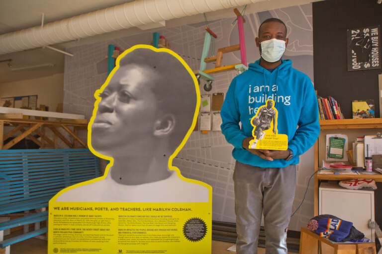 Creator and North Philadelphia resident Ian Lipford holds a prototype of an installation of Mike Green, a basketball player from the neighborhood who went on to win awards as a college player. (Kimberly Paynter/WHYY)