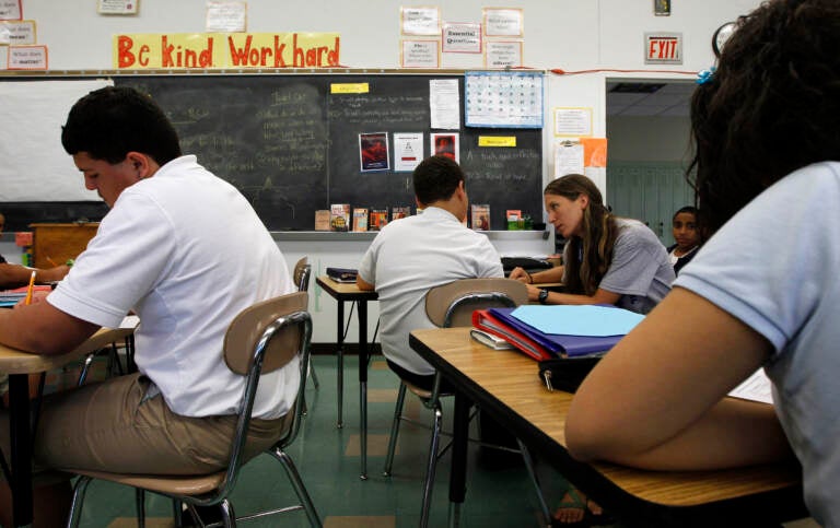 Teacher Laura Kangay, (center) helps a student with his reading at Lincoln Middle School Friday, Sept. 30, 2011 in Lancaster, Pa. Financial woes have forced school districts to shed thousands of teaching jobs, adopt a four-day school week and cut electives such as art. And the budget situation probably wont improve any time soon for school districts that rely heavily on state and local tax dollars. But what might happen in a best-case financial scenario that assumes strong economic growth next year?