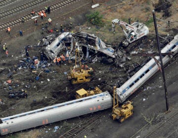 In this May 13, 2015, file photo, emergency personnel work near the wreckage of a New York City-bound Amtrak passenger train following a derailment that killed eight people and injured about 200 others in Philadelphia