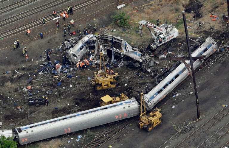 In this May 13, 2015, file photo, emergency personnel work near the wreckage of a New York City-bound Amtrak passenger train following a derailment that killed eight people and injured about 200 others in Philadelphia