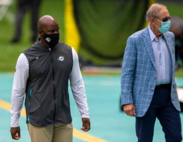 Miami Dolphins head coach Brian Flores and Miami Dolphins owner Stephen Ross wearing masks on the sidelines before taking on the Seattle Seahawks during an NFL football game, Sunday, Oct. 4, 2020, in Miami Gardens, Fla. (AP Photo/Doug Murray)