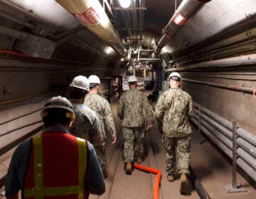 In this Dec. 23, 2021, photo provided by the U.S. Navy, Rear Adm. John Korka, Commander, Naval Facilities Engineering Systems Command (NAVFAC), and Chief of Civil Engineers, leads Navy and civilian water quality recovery experts through the tunnels of the Red Hill Bulk Fuel Storage Facility, near Pearl Harbor, Hawaii. The Navy is scrambling to contain what one lawmaker has called a “crisis of astronomical proportions” after jet fuel leaked from an 80-year-old Hawaii tank farm, seeped into a drinking water well and polluted the water streaming out of faucets in Pearl Harbor military housing