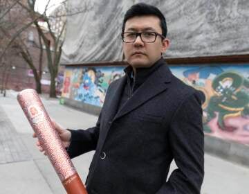 Kamaltürk Yalqun holds the aluminium Olympics torch he carried at the 2008 Beijing Olympic Games at the age of 17, on Friday, Jan. 28, 2022, in Boston. The decade after the Games saw Beijing impose policies on his region of Xinjiang that split apart his family and Uyghur community. Today, he is an activist in the United States calling for a boycott of the 2022 Winter Games, which will see the Olympic flame returned to Beijing.