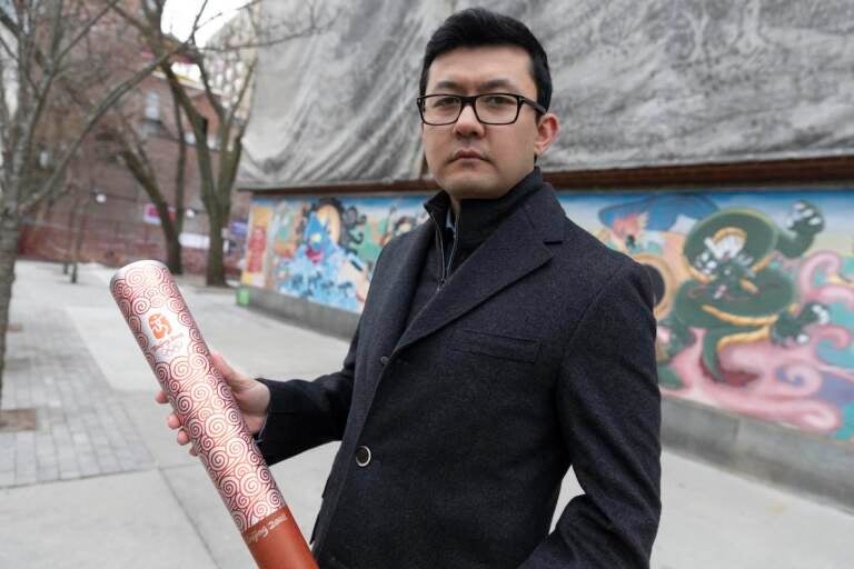 Kamaltürk Yalqun holds the aluminium Olympics torch he carried at the 2008 Beijing Olympic Games at the age of 17, on Friday, Jan. 28, 2022, in Boston. The decade after the Games saw Beijing impose policies on his region of Xinjiang that split apart his family and Uyghur community. Today, he is an activist in the United States calling for a boycott of the 2022 Winter Games, which will see the Olympic flame returned to Beijing.