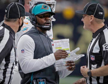 File photo: Miami Dolphins head coach Brian Flores, center, talks to down judge David Oliver (24) during the first half of an NFL football game against the New Orleans Saints Monday, Dec. 27, 2021, in New Orleans. Fired Miami Dolphins Coach Brian Flores sued the NFL and three of its teams Tuesday, Feb. 1, 2022 saying racist hiring practices by the league have left it racially segregated and managed like a plantation