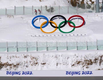 Biathletes skate above the Olympic rings during practice at the 2022 Winter Olympics, Thursday, Feb. 3, 2022, in Zhangjiakou, China. (AP Photo/Kirsty Wigglesworth)