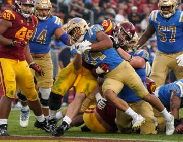 File photo: UCLA running back Zach Charbonnet (24) runs the ball in for a touch down as Southern California defensive lineman Jacob Lichtenstein (97) tries to stop him during the second half of an NCAA college football game Saturday, Nov. 20, 2021, in Los Angeles. An advocacy group for college athletes has filed a complaint with the National Labor Relations board in the next step in a push to give employee status to college athletes and afford them the right to competitive pay, collective bargaining and other benefits and protections. The National College Players Association on Tuesday, Feb. 8, 2022 filed the unfair labor practice charges against the NCAA, Pac-12 Conference, UCLA and the University of Southern California