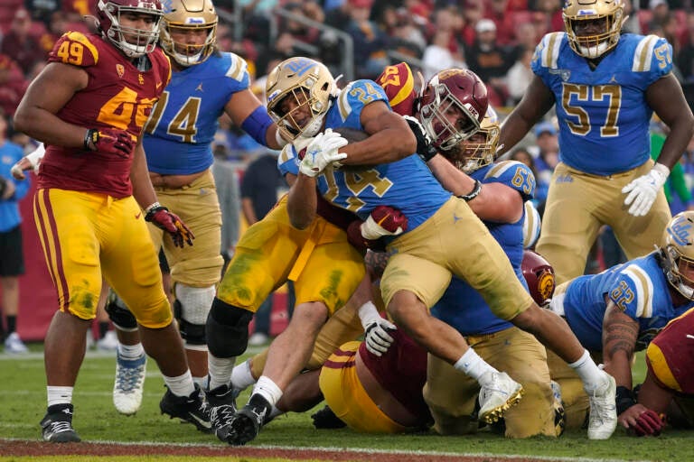 File photo: UCLA running back Zach Charbonnet (24) runs the ball in for a touch down as Southern California defensive lineman Jacob Lichtenstein (97) tries to stop him during the second half of an NCAA college football game Saturday, Nov. 20, 2021, in Los Angeles. An advocacy group for college athletes has filed a complaint with the National Labor Relations board in the next step in a push to give employee status to college athletes and afford them the right to competitive pay, collective bargaining and other benefits and protections. The National College Players Association on Tuesday, Feb. 8, 2022 filed the unfair labor practice charges against the NCAA, Pac-12 Conference, UCLA and the University of Southern California