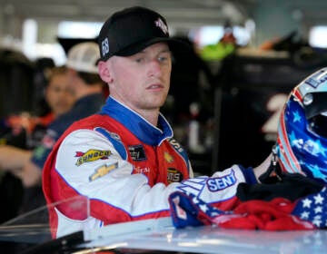 Brandon Brown moves his helmet after a NASCAR Xfinity Series auto race practice Friday, Feb. 18, 2022, at Daytona International Speedway in Daytona Beach, Fla. (AP Photo/Chris O'Meara)