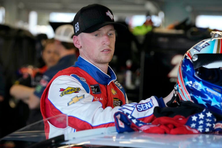 Brandon Brown moves his helmet after a NASCAR Xfinity Series auto race practice Friday, Feb. 18, 2022, at Daytona International Speedway in Daytona Beach, Fla. (AP Photo/Chris O'Meara)