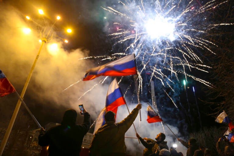 People wave Russian national flags celebrating the recognizing the independence in the center of Donetsk, the territory controlled by pro-Russian militants, eastern Ukraine, late Monday, Feb. 21, 2022. In a fast-moving political theater, Russian President Vladimir Putin has moved quickly to recognize the independence of separatist regions in eastern Ukraine in a show of defiance against the West amid fears of Russian invasion in Ukraine. (AP Photo/Alexei Alexandrov)