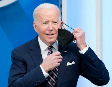 President Joe Biden removes his face mask to speak in the South Court Auditorium in the Eisenhower Executive Office Building on the White House complex, Tuesday, Feb. 22, 2022, in Washington