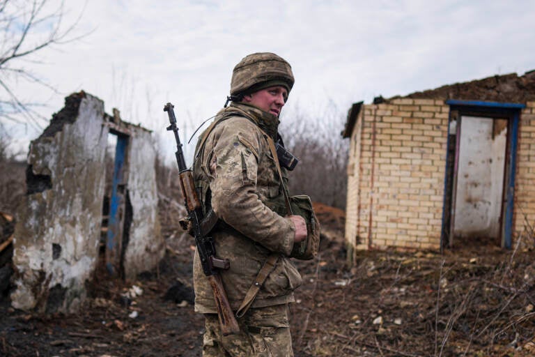 A Ukrainian serviceman stands at his position at the line of separation between Ukraine-held territory and rebel-held territory near Svitlodarsk, eastern Ukraine, Wednesday, Feb. 23, 2022. U.S. President Joe Biden announced the U.S. was ordering heavy financial sanctions against Russia, declaring that Moscow had flagrantly violated international law in what he called the 