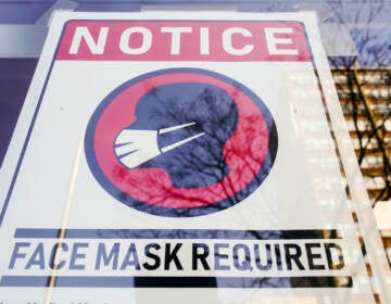 File photo: A sign requiring masks as a precaution against the spread of the coronavirus is posted on a store front in Philadelphia, on Feb. 16, 2022. (AP Photo/Matt Rourke, File)