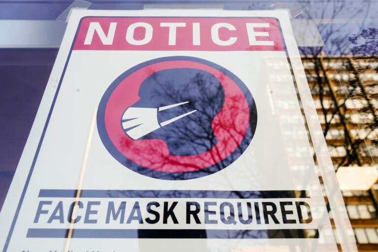 File photo: A sign requiring masks as a precaution against the spread of the coronavirus is posted on a store front in Philadelphia, on Feb. 16, 2022. (AP Photo/Matt Rourke, File)