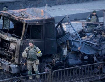 Ukrainian troops inspect the site following a Russian airstrike in Kyiv, Ukraine, Saturday, Feb. 26, 2022