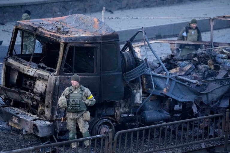 Ukrainian troops inspect the site following a Russian airstrike in Kyiv, Ukraine, Saturday, Feb. 26, 2022