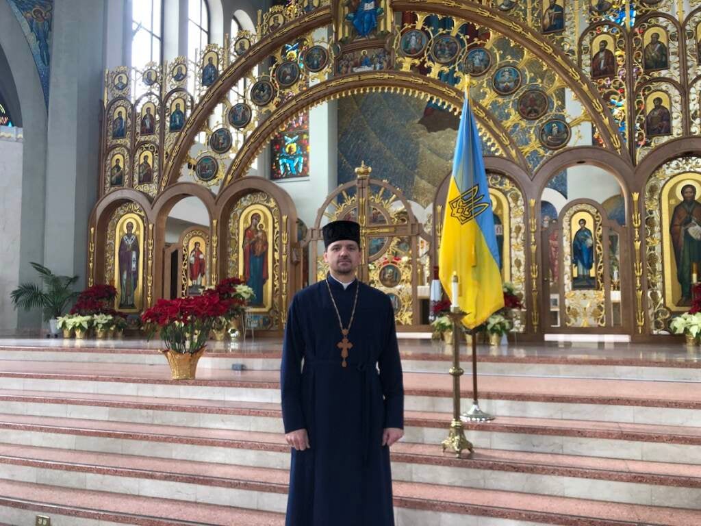 Father Roman Pitula of the Philadelphia Ukrainian Catholic Church standing next to the church's candle they lit in hopes for peace in Ukraine