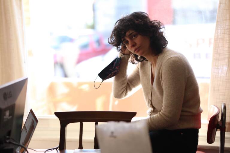 Nina Feldman sits while holding a face mask