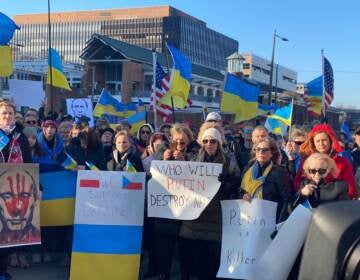 People hold up signs in support of Ukraine at a rally in Philly