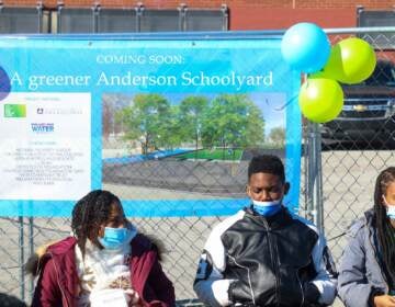 People are seen wearing masks at a press event for a new schoolyard