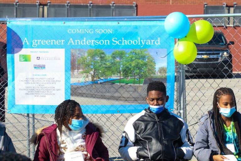 People are seen wearing masks at a press event for a new schoolyard