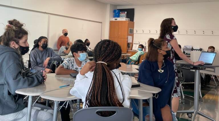 Students sit at their desks while wearing face masks