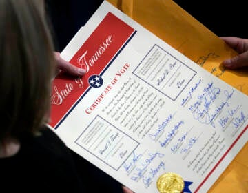 Staff members hold the certification of Electoral College votes from Tennessee