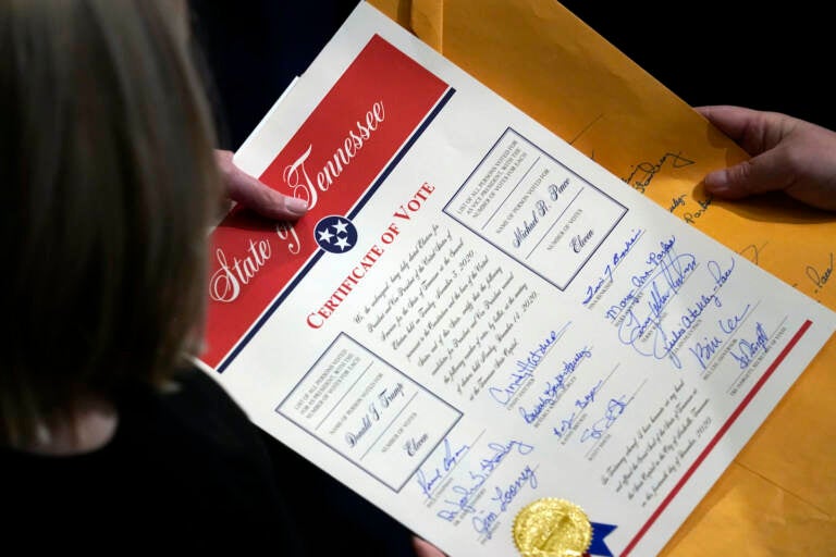 Staff members hold the certification of Electoral College votes from Tennessee