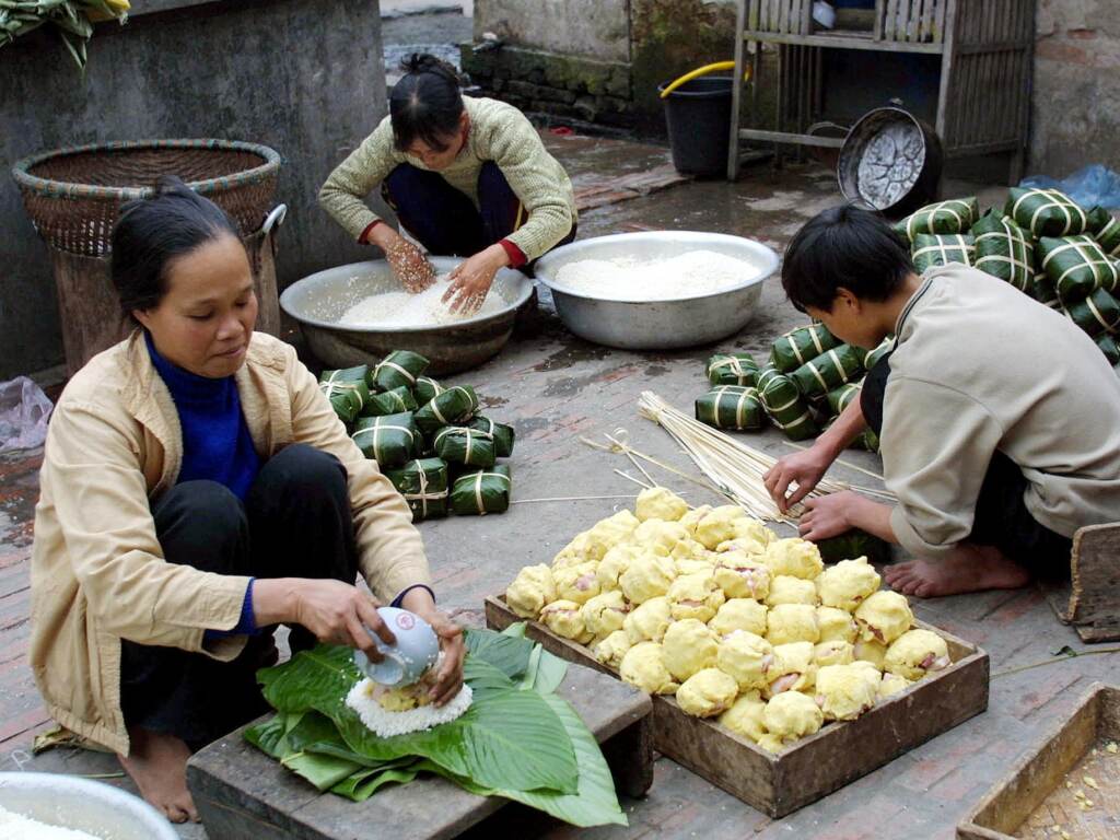 Members of a family make the traditional Lunar New Year "banh chung" or rice cakes